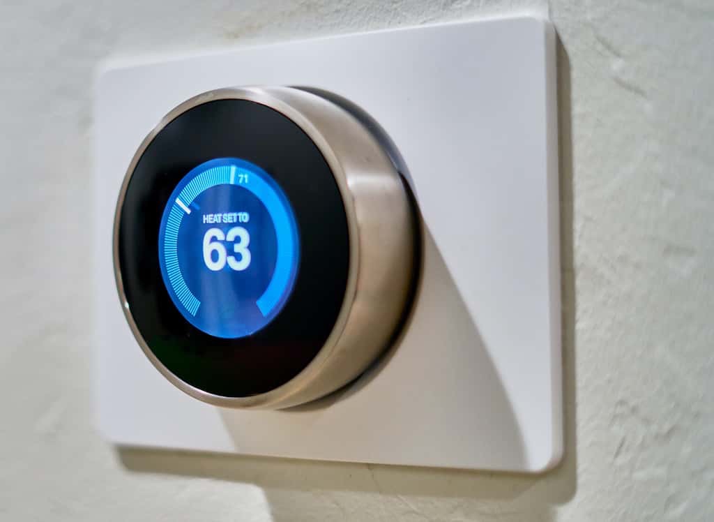 A round smart thermostat on a wall
